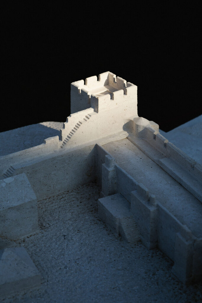 A close up of the stone model shows carved steps leading up to one of the towers.