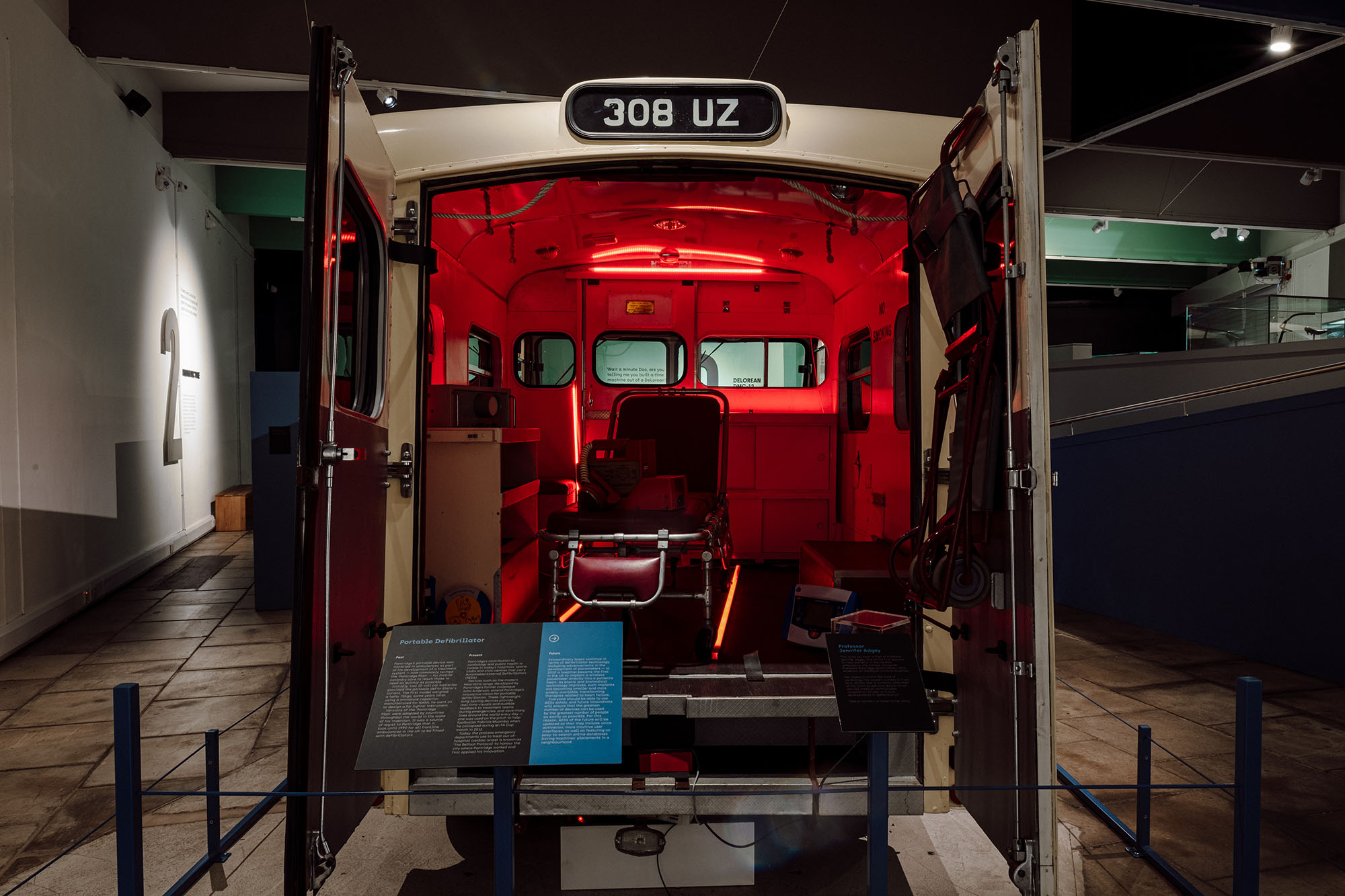 the interior of the ambulance is shown with a graphic panel titled 'Portable Defibrillator' in front.